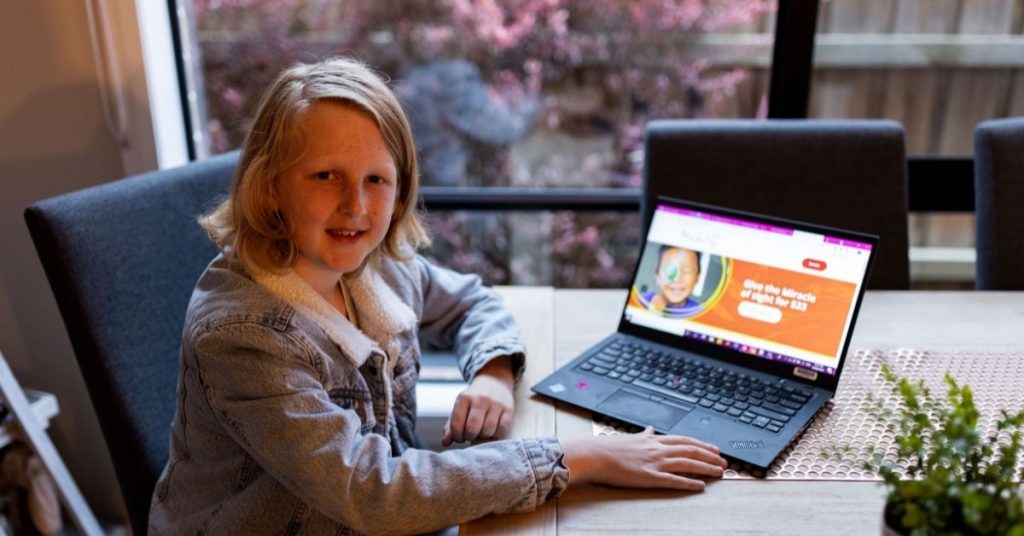 curtis sits at a laptop with te cbm donation page up on the screen